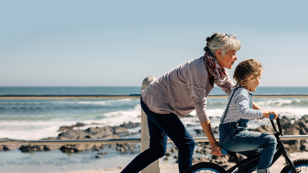 Dynamiczna babcia pomagająca wnukom jeździć na rowerze